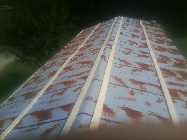 Rusted metal roof panels with new wood purlins before replacement — Storm Damage Roof Repair in Ethelsville by Roofing Brothers