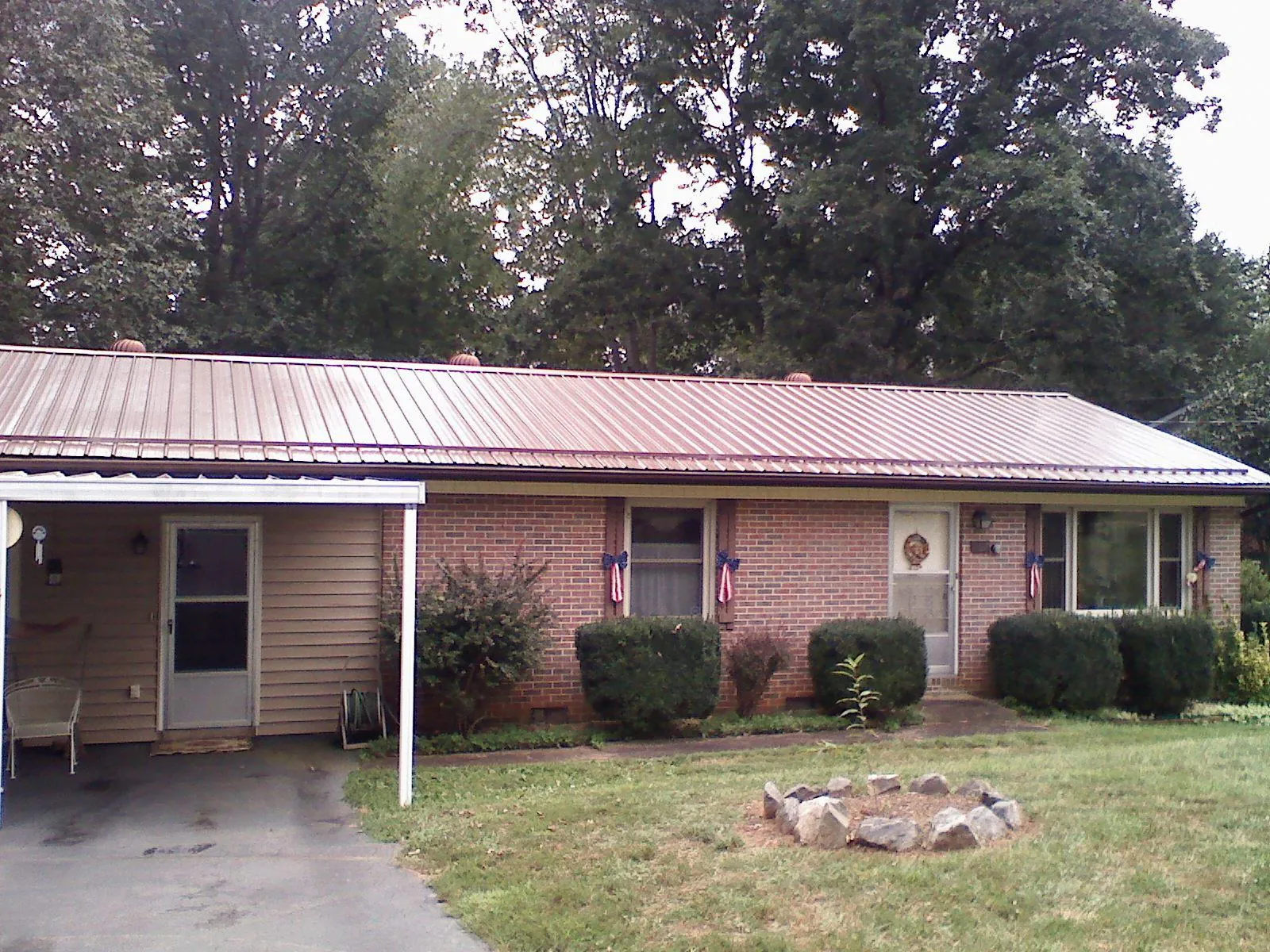 Bronze metal roof and carport on a brick ranch home — Roof Repair work by our crew in Ethelsville